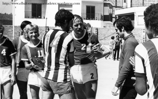 El capità de l’equip sarrianenc, Jaume Casadevall, entrega al capità rival, el trofeu corresponent. Al fons de la pista, Xevi Masó, s’ho mira llunyanament, tot encenent un cigarret.